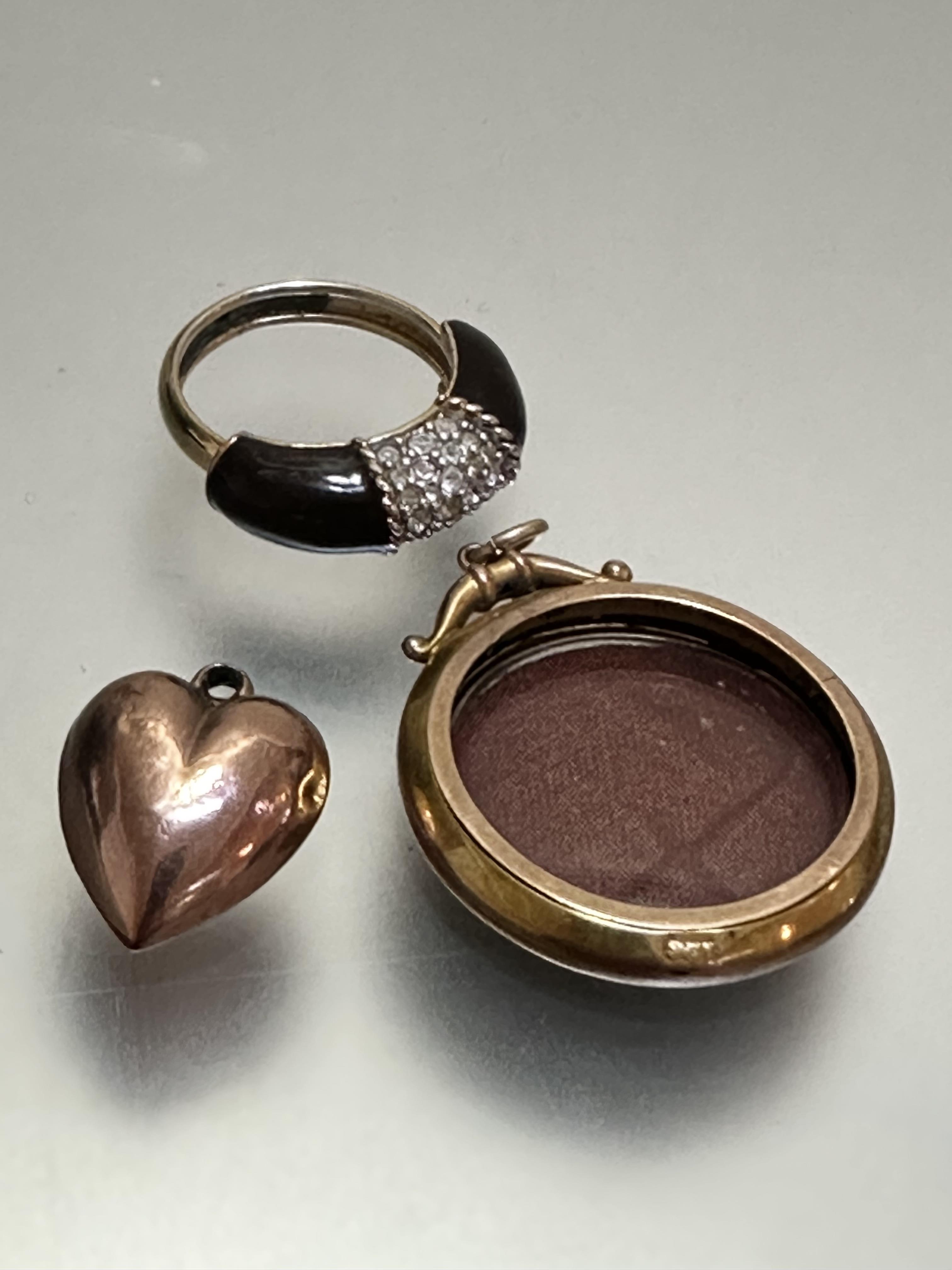 A 9ct gold double-sided glazed locket, (d 3cm), a yellow metal heart shaped pendant and a yellow