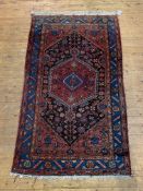 A hand-knotted Iranian Hamadan rug, the red field with lozenge medallion and all-over geometric