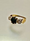 An 18ct gold three stone ring, set oval sapphire, table rubbed and scratched, mounted in claw