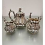 A Victorian Epns three-piece panelled baluster tea service with floral finial and scroll handle to