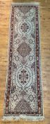 A Persian Tabriz runner rug, hand knotted, the ivory ground decorated with stylized foliate and