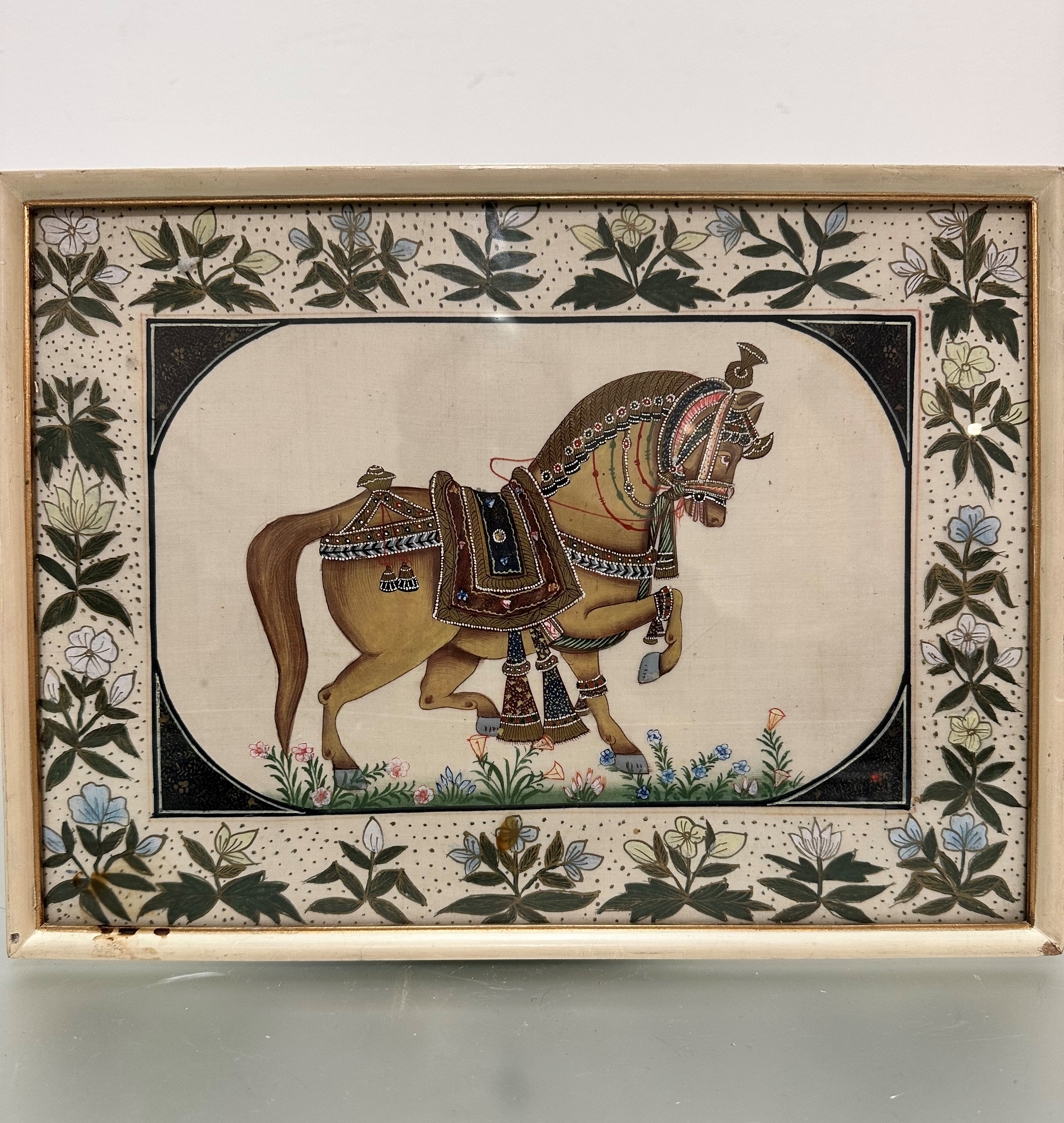 A Mogul style Indian painting of a ceremonial horse, watercolour on fabric enclosed within a foliate