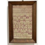 A 19th century alphabet and numbers sampler, worked in red and green threads, signed "A.G.C. Dalziel