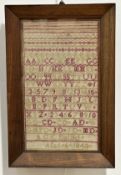 A 19th century alphabet and numbers sampler, worked in red and green threads, signed "A.G.C. Dalziel