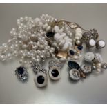 A collection of paste pearl necklaces, a white plastic necklace, a white metal and paste set and