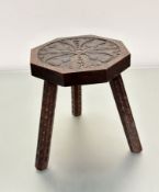 A Scottish oak octagonal stool with thistle and leaf carved design to top, on carved dart