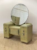 An Art Deco period green painted oak dressing table, the circular swing mirror over five drawers,