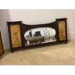 An early 20th century carved mahogany over mantel mirror, with bevelled plate flanked by two