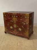A Chinese side cabinet, red lacquered and with gilt chinoiserie decoration, fitted with two
