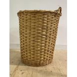 A large cylindrical wicker twin handled log basket, H83cm, W70cm