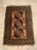 A Hand Knotted Afghan bokhara rug, three guls on a burnt orange field, enclosed by a multi line