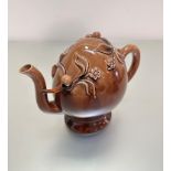 A Brameld Cadogan pottery teapot with brown glaze design and scrolling leaf and flower moulded,