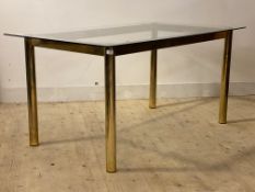 A mid century post modern dining table, the rectangular glass top raised on gilt and lacquered brass