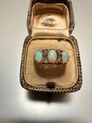 An 18ct gold three-stone water opal ring with three rose cut spacers to each shoulder, mounted in