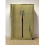 An Art Deco period green painted oak wardrobe, the doors with turned and wrought handles enclosing