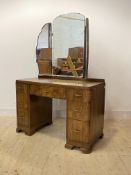 A 1920s figured walnut dressing table, with three swing mirror over one long and six short graduated