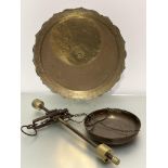 A brass hanging adjustable set of scales complete with brass pannier and a circular eastern brass