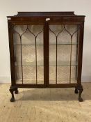 An early 20th century mahogany display cabinet, the ledge back over two astragal glazed doors
