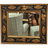 An Art Nouveau black enamelled and gilded rectangular wall mirror with water lily and leaf scrolling