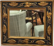 An Art Nouveau black enamelled and gilded rectangular wall mirror with water lily and leaf scrolling