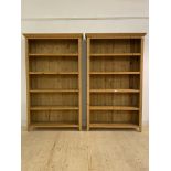 A pair of pine open bookcases, each with four fixed shelves, raised on stile supports, H200cm,
