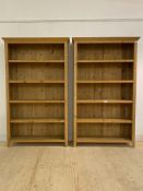 A pair of pine open bookcases, each with four fixed shelves, raised on stile supports, H200cm,