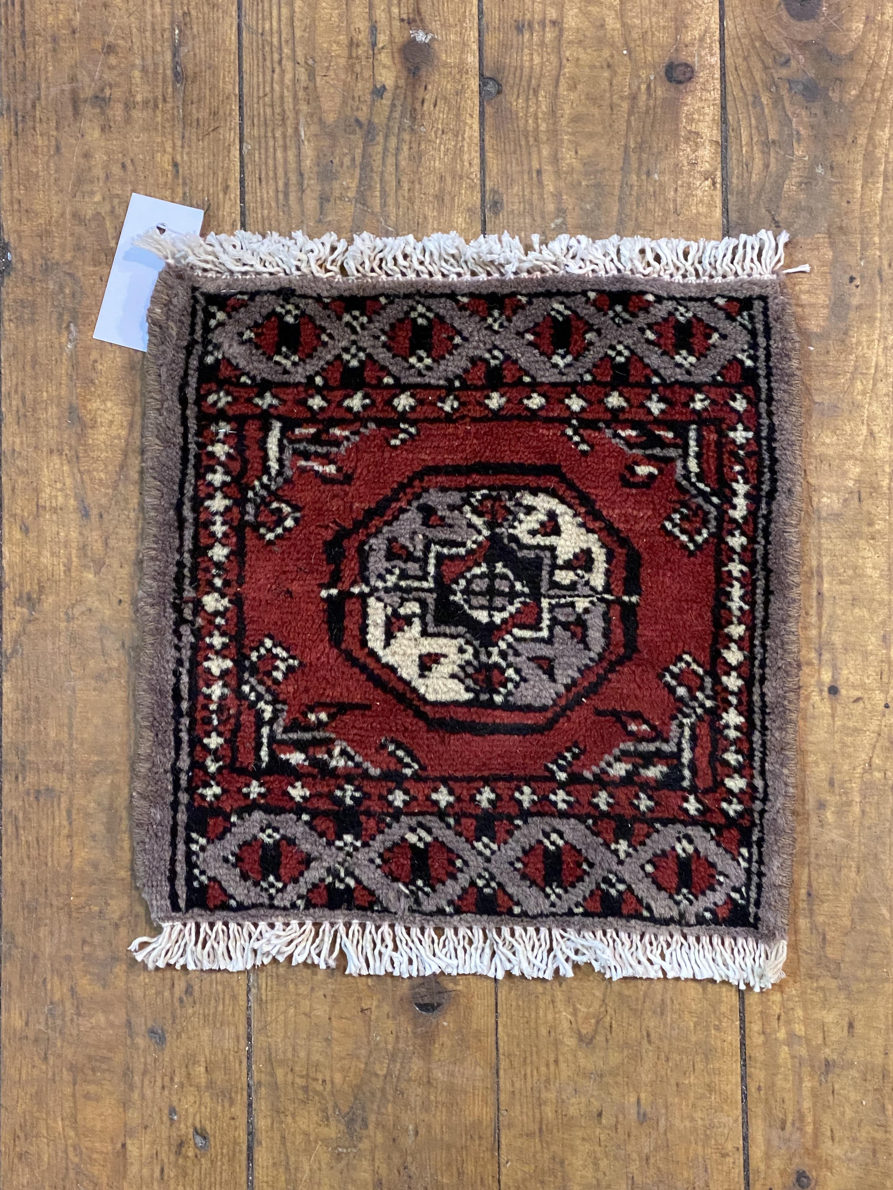 A hand knotted Persian Mori jaldar table rug, centred with gul, 20cm x 20cm