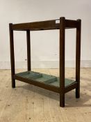 An early 20th century oak two division stick stand, with original green drip tray, H69cm, W69cm,