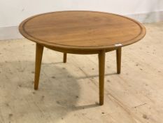 A mid century vintage teak and walnut coffee table, the circular top with incised border raised on