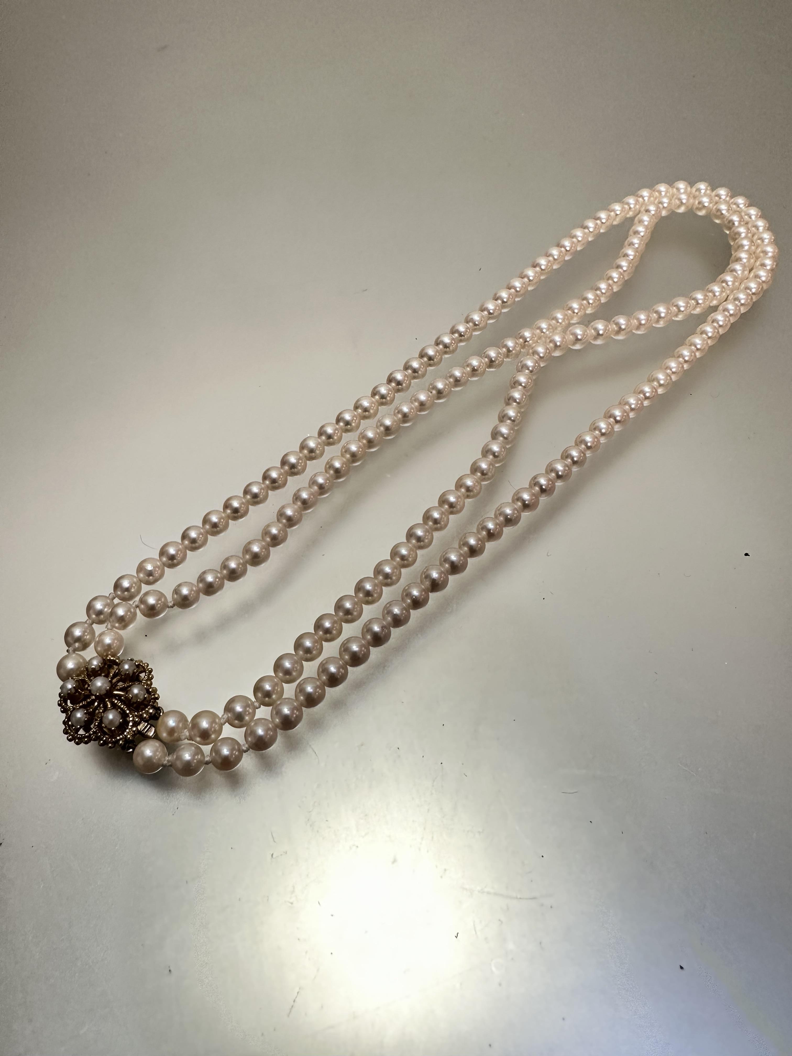 A cultured two strand pearl necklace, (each pearl d 0.3cm approximately) with 9ct gold seed pearl