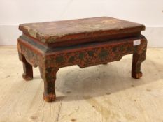 A 19th century Chinese red lacquered low table, the top with incised mountainous landscape over