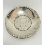 An Austrian Thaler 1780 inset into a white metal 800 stamped circular gadroon rimmed dish, (d :