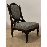 A late Victorian mahogany drawing room chair, the well carved and reeded frame enclosing upholstered