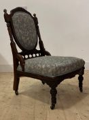 A late Victorian mahogany drawing room chair, the well carved and reeded frame enclosing upholstered