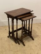 An early 20th century walnut nest of three tables, raised on ring turned and sledge supports, H57cm,