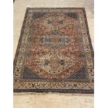 A Persian design Shiraz rug, the busy red field decorated with stylised floral and animal motifs,