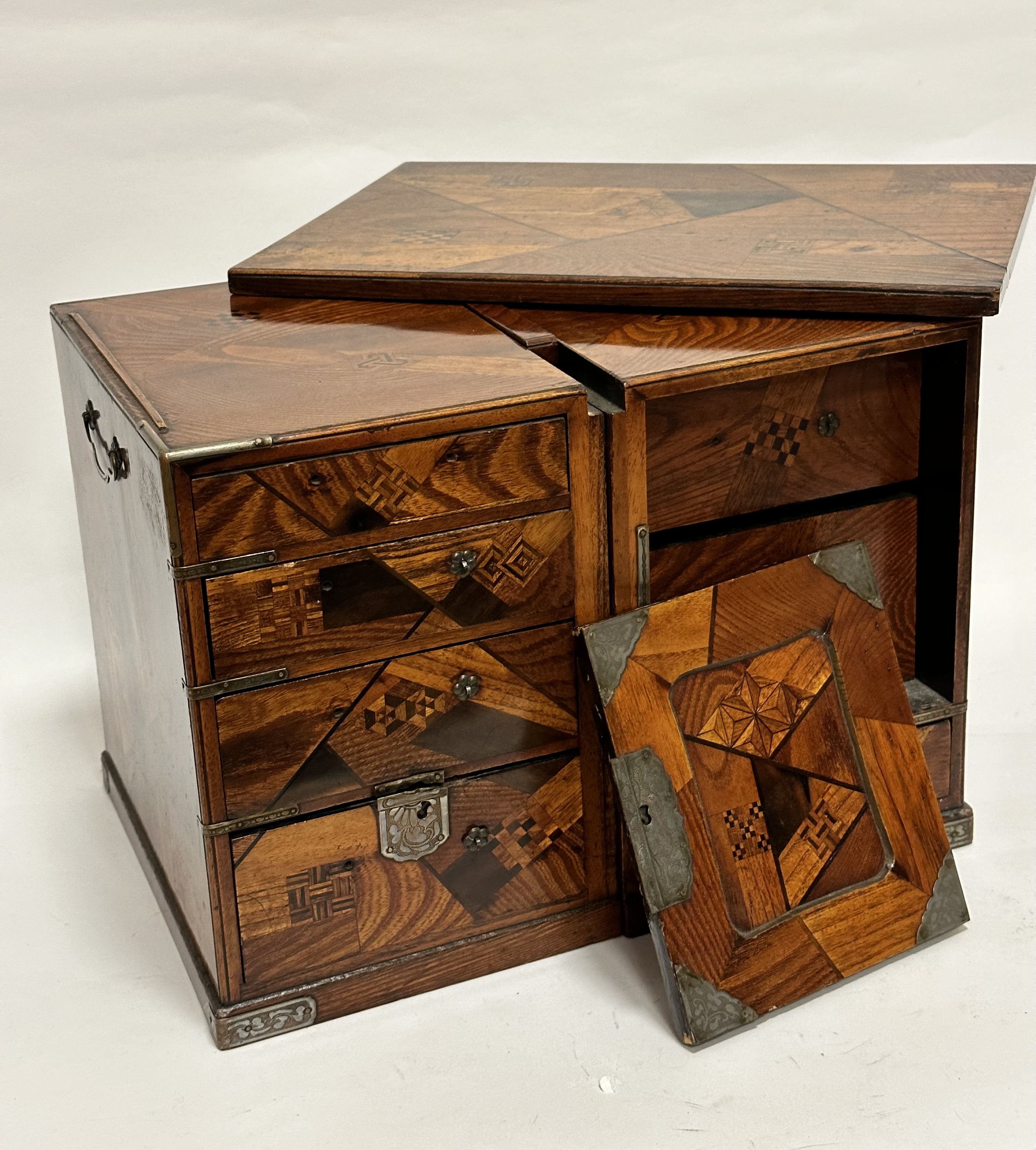 A late 19thc Japanese inlaid mixed wood two section chest, the lift off top with inlaid panels in