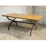A modern dining table, the varnished pine top over wrought iron 'X' form base, H74cm, 182cm x 94cm