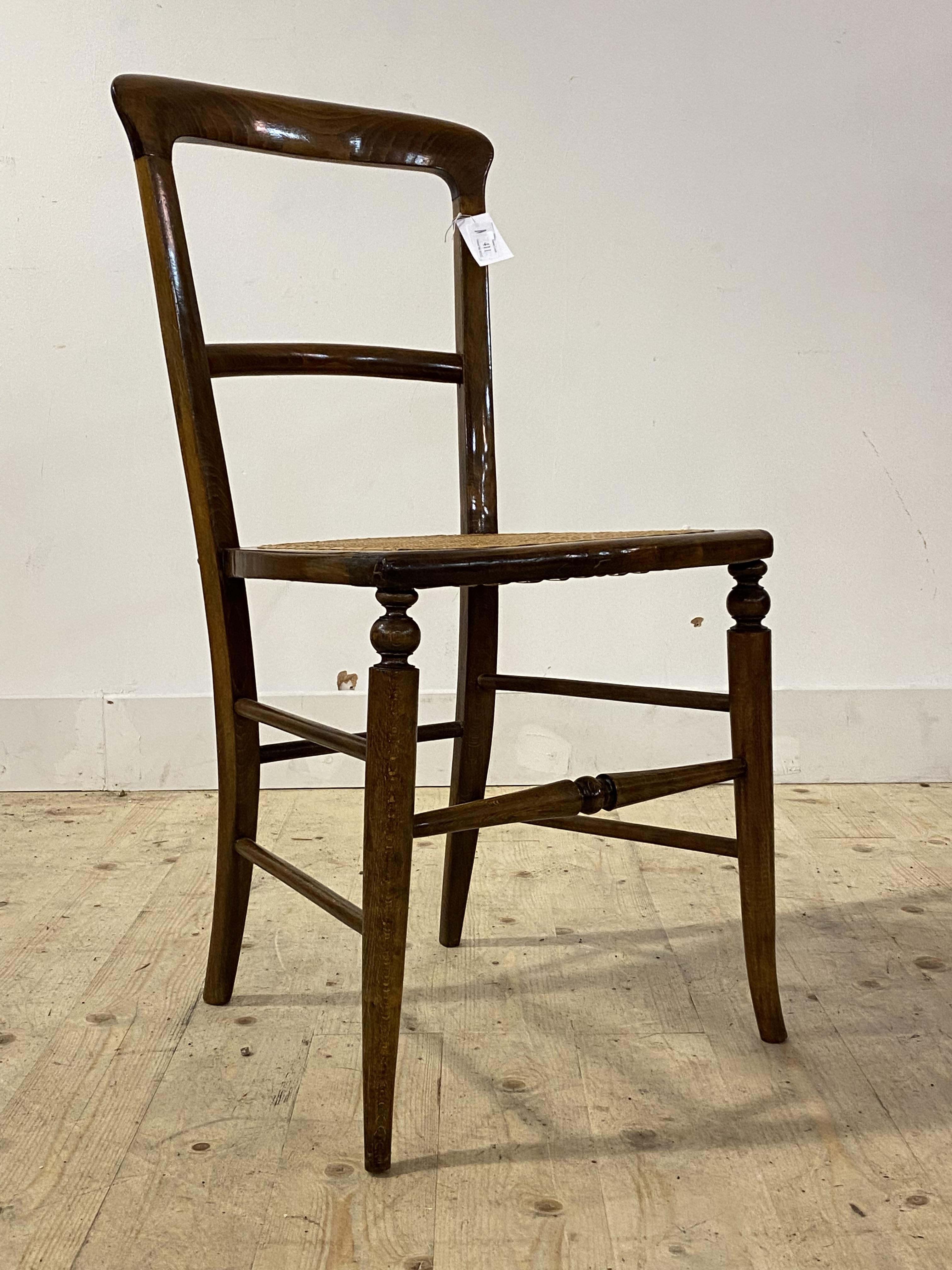 An Edwardian stained beech side chair, with rail back, cane seat and turned supports and stretchers,