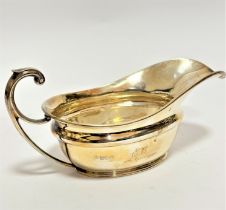 A modern Sheffield silver sauce boat of helmet style shape with C-scroll handle and engraved