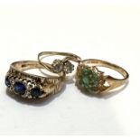 A 9ct gold cross over ring set with cubic zirconia's, a 9ct gold emerald cluster style ring and a