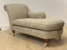 A modern floral upholstered chaise longue, raised on turned supports with brass cup castors,