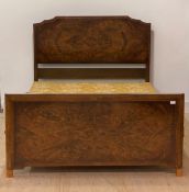 A 1920s figured walnut 4'6" double bed, with panelled head and foot board, a folding upholstered box