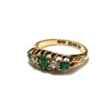 An 18ct gold three stone emerald and two stone diamond ring mounted in claw setting, the centre