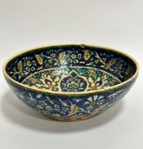 A late 19th early 20thc Moorish style bowl decorated with stylised flower and leaf design, chip to