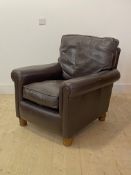 A Modern leather upholstered easy chair, raised on turned oak supports, H90cm, W81cm, D91cm