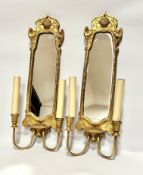 A pair of gilt wood wall appliques with shell shaped surmount and mirror panelled backs with twin