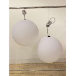 A pair of contemporary ceiling pendent light fittings, each with a large spherical moulded plastic