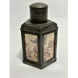 A reproduction pewter octagonal Chinese panelled tea canister with landscape figures and domed