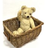 A white mohair articulated straw filled teddy bear with inset glass eyes, stitched nose and faded
